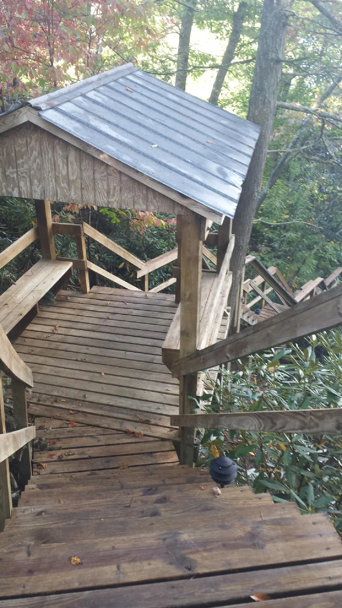Metal roofed shelter over wooden steps on a wooded walkway — Skylight Repair & Installation work by our crew in Spencer